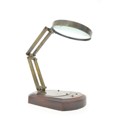 15 - Desktop magnifying glass with adjustable metal mount, bears label 'Watkins & Hill Opticians, London ... 