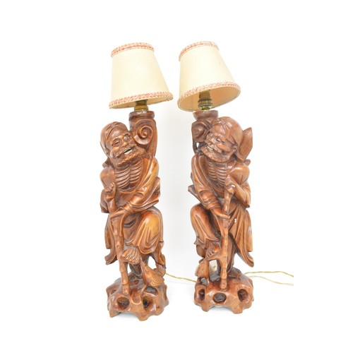 59 - A pair of oriental lamps, carved form of elder holding staff. Untested AF.
