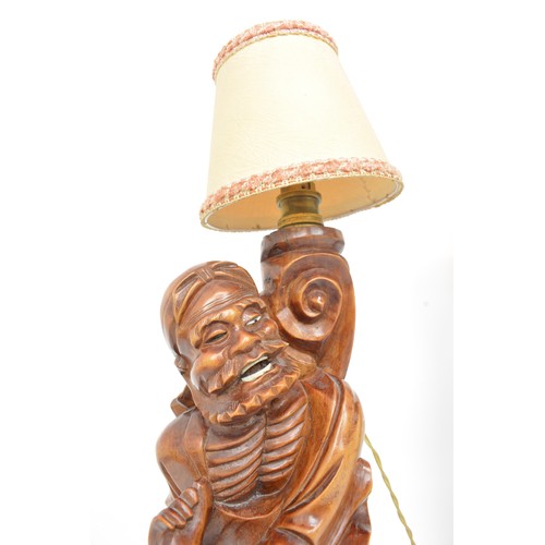 59 - A pair of oriental lamps, carved form of elder holding staff. Untested AF.
