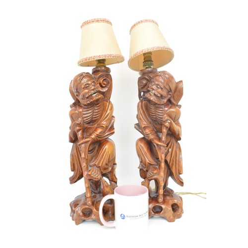 59 - A pair of oriental lamps, carved form of elder holding staff. Untested AF.