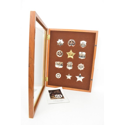 Recreation of The Official Badges of the Great Western Lawmen, struck in sterling silver and 22 carat gold on sterling by Franklin Mint in 1987, x12 badges presented in display case of wood with glazed top, approx L51cm x 40cm