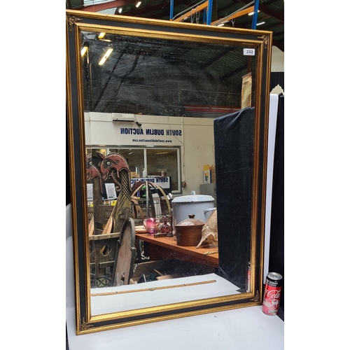 222 - Large Black and gold bevelled mirror. Approx 100cm x 70cm