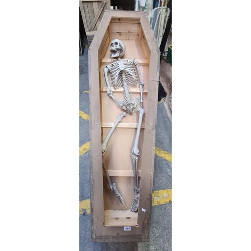 84 - Wooden coffin with a partial faux skeleton 184cm x 63cm x 30cm tall.