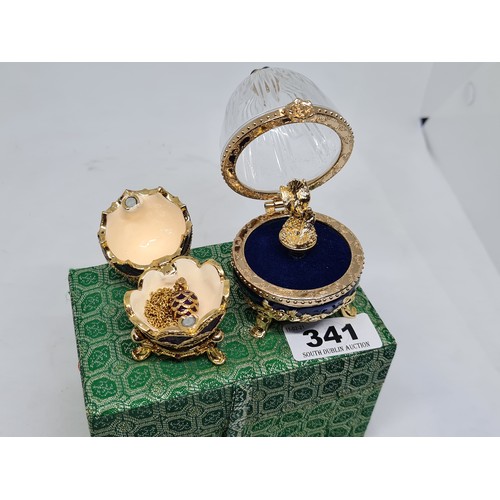 341 - 2 x decorative eggs in cast metal painted and jewelled with glass and a third small egg on a gold ch... 