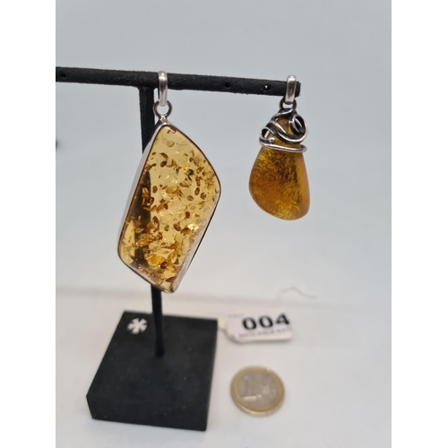 4 - Two sterling silver amber pendents. 21g