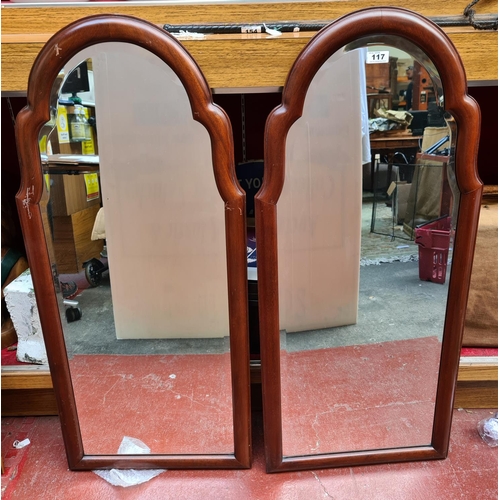 117 - Two shaped, bevelled, dressing mirrors.