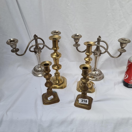 318 - Three pairs of matching candlesticks. Four in brass and two in silver plate.