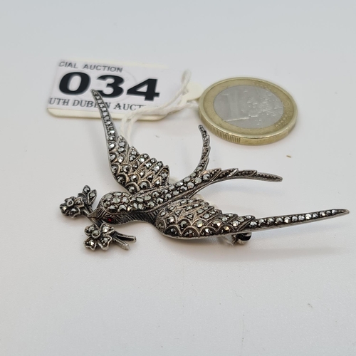 34 - Sterling Silver 1940s Marcasite brooch of a bird in flight holding a flower.