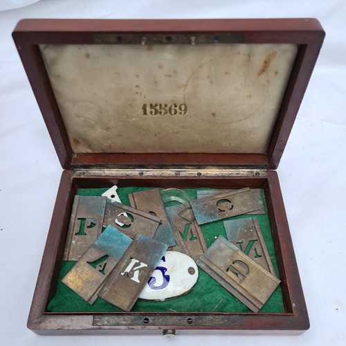 175 - Small Mahogany and inlaid box containing a small collection brass stenciling letter plates