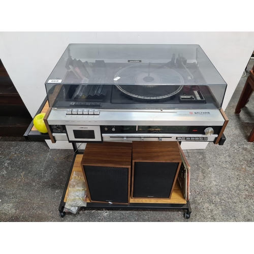 669 - Walthan cassette radio/record player including two wooden cased speakers, mobile stand, and 8 LP's