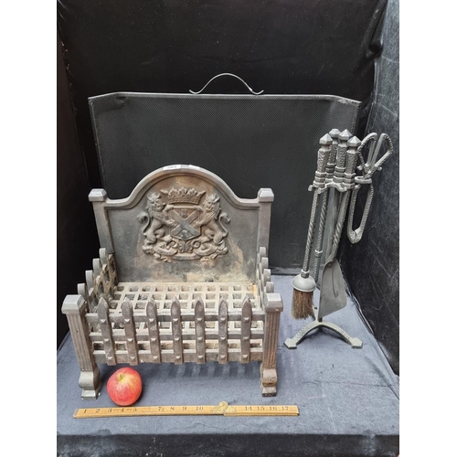 203 - Vintage cast metal fire grate with coat of arms, matching companion stand and fire guard.