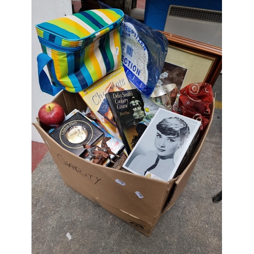 289 - Box of mixed interest items,cookery books, cowboy figurine, candles and sunglasses and an Audrey Hep... 