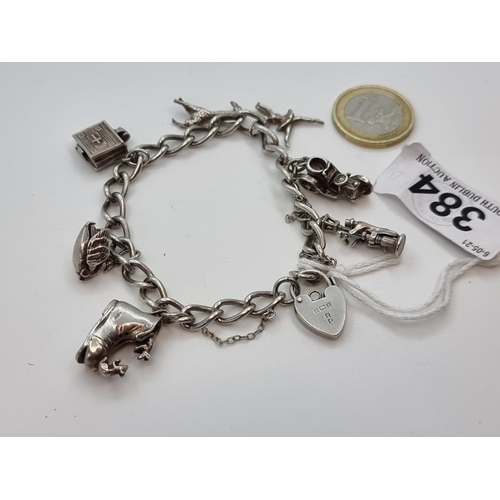 384 - Silver locket 6 charm bracelet, with safety chain. Birmingham 1947. Weight of bracelet 32.4g.