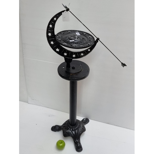 530 - Cast metal sundial, depicting, sun, moon and stars. Very heavy. Overall height 99cm.