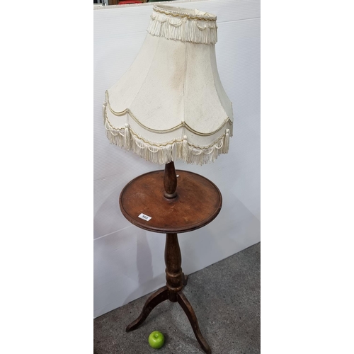 565 - Vintage wine table with built in lamp including fringed shade. Measures 124cm overall.