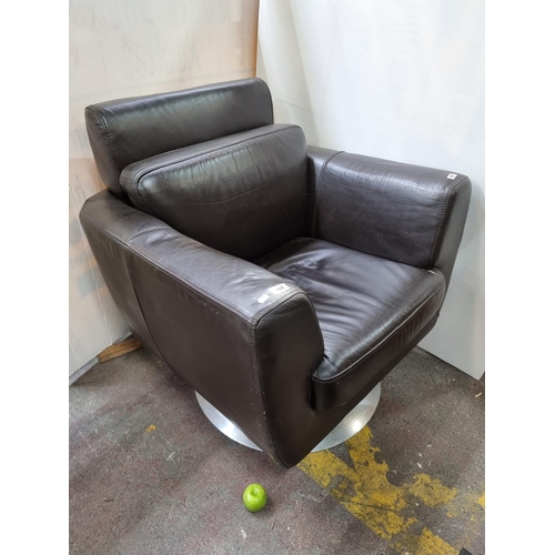 568 - Leather swivel armchair on metal base. Ver comfortable and in good condition. Overall height 85cm.