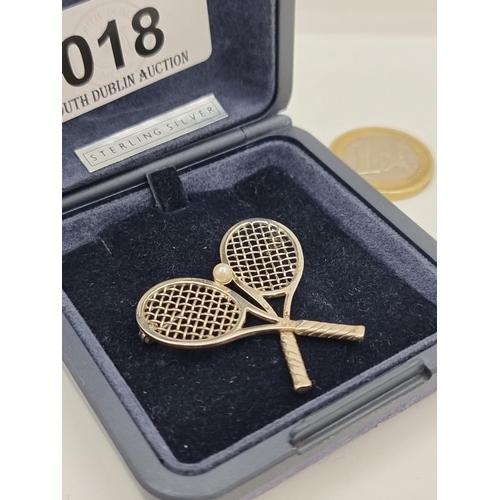 18 - A sterling silver brooch depicting cross tennis rackets with pearl set to centre. Weight 3.4 g. In p... 