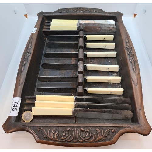 745 - Nicely carved wooden tray with 12 Ivorine handled Knifes.