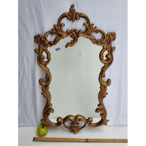 283 - A Baroque Style Mirror with gilt-effect frame.