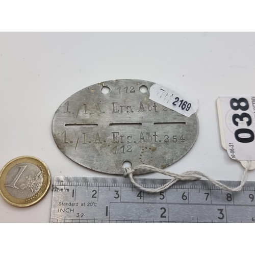38 - An oval metal WW2 dog tag, with markings ERS.ABT.254