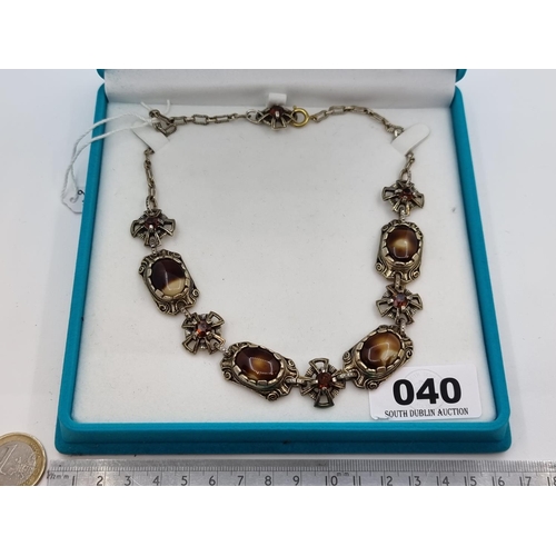 40 - A vintage Celtic designed stone necklace, set with alternate garnet and agate stones, on a pinchbeck... 