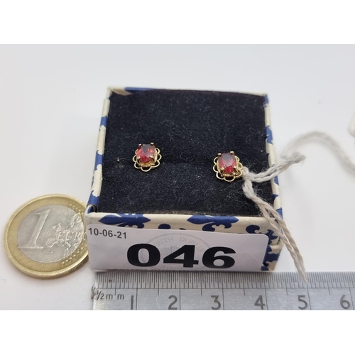46 - A pair of 9 carat gold natural ruby stone stud earrings in foliate designed setting. A very pretty e... 
