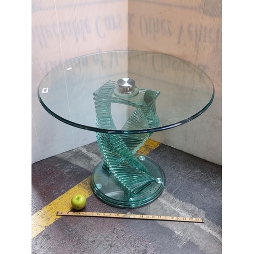 501 - A circular glass coffee table with an interesting spiral stepped stand and circle acrylic base. Grea... 