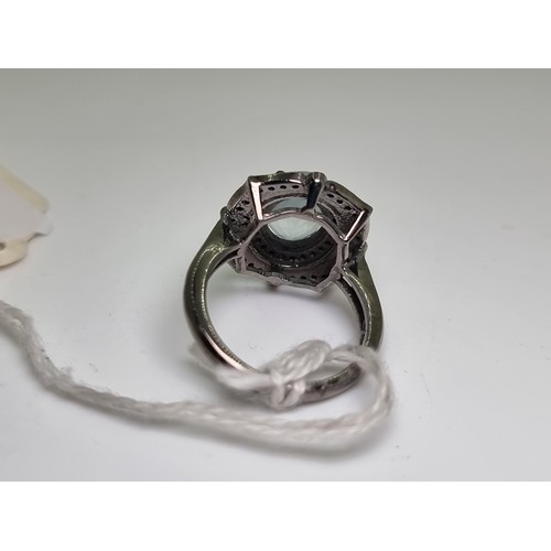 53 - An extremely attractive large aquamarine stone ring with diamond cluster surround. Weight 6g, size O... 