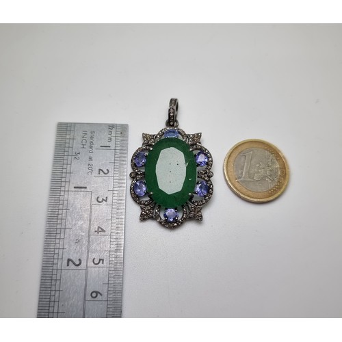 55 - Star Lot : An extremely attractive sterling silver oval shaped pendant with a fine emerald centre st... 