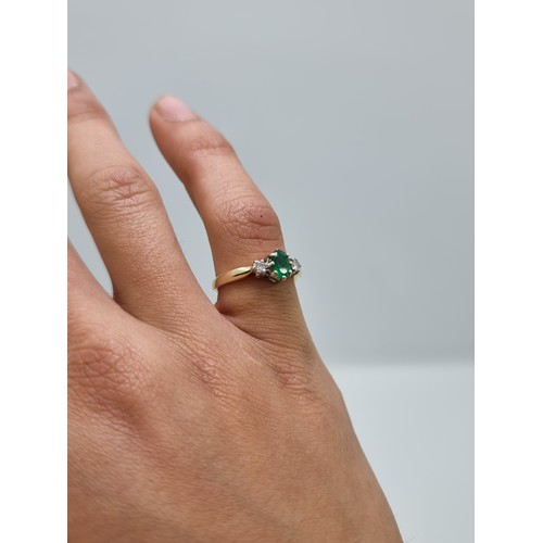 410 - A very pretty 9 carat gold three stone emerald and diamond ring. Weight 2.1g, size L.