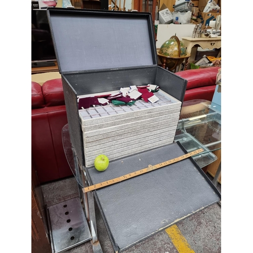 548 - A commercial jewellery vendors travel case with ten removable presentation trays and a large collect... 
