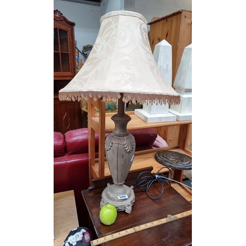 549 - A large ornate table lamp with urn shaped base and tan damask shade with bead fringing.