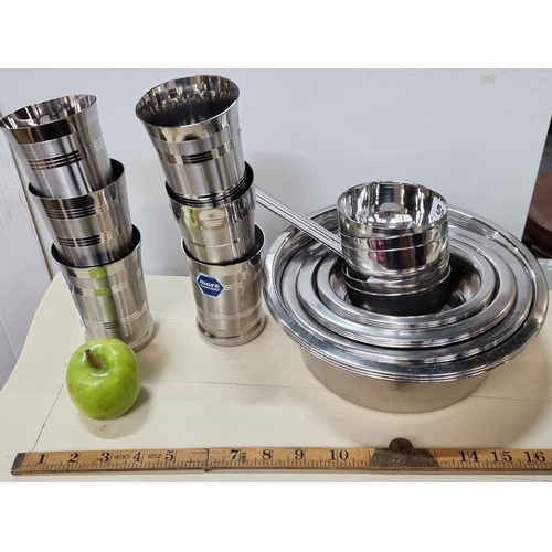 596 - A large quantity of stainless steel stacking kitchen ware.