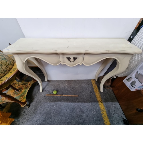 598 - A large cream side table with long sabre legs and one drawer. Beautiful shape.