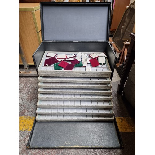 548 - A commercial jewellery vendors travel case with ten removable presentation trays and a large collect... 