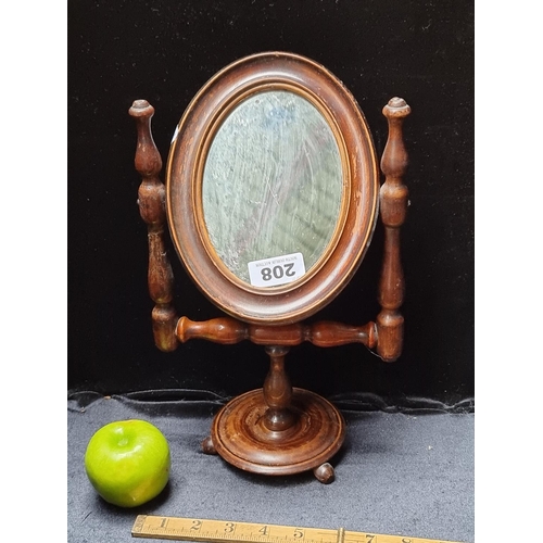 208 - An antique wooden shaving mirror on a turned wooden stand and a set of cowbells.