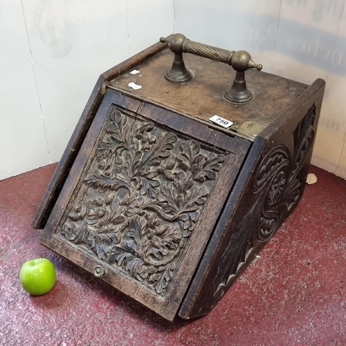 750 - An wooden coal scuttle ornately carved with oak and acorn decoration.