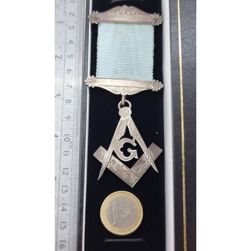 422 - A collection of Masonic items, containing a Sterling silver Masonic medal and ribbon in presentation... 