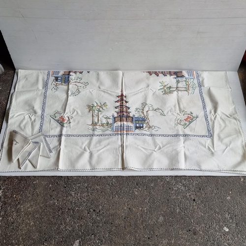 734 - A set of matching embroidered tablecloth and five napkins with Chinese pagoda design.