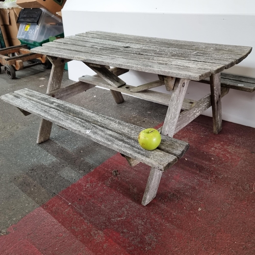 763 - A wooden children's picnic bench with a parasol hole.