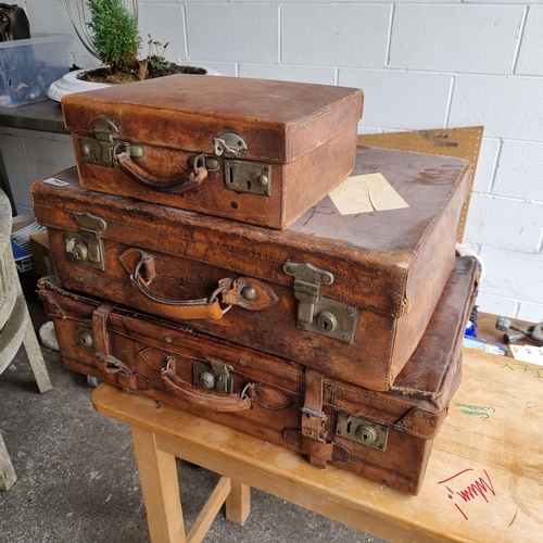 766 - A collection of three very handsome antique leather suitcases, graduating in size.