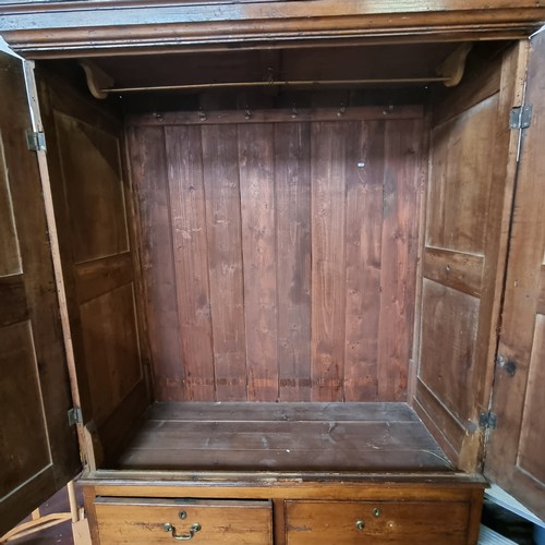 765 - An antique two-door mahogany wardrobe with two drawers and a large amount of hanging space. Key incl... 