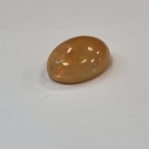 66 - Oval cabochon dark Opel with a lovely play of colours Weight 4.51 carats, with IDT certificate.