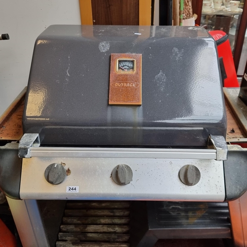 244 - An Outback gas barbecue grill with three burners. With a Calor gas drum.