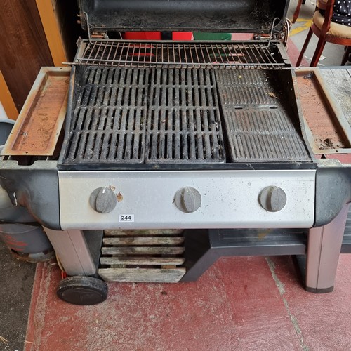 244 - An Outback gas barbecue grill with three burners. With a Calor gas drum.