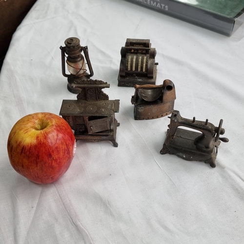 714 - A collection of five copper ''Play me''pencil sharpeners  miniature furnishings including an oven, s... 