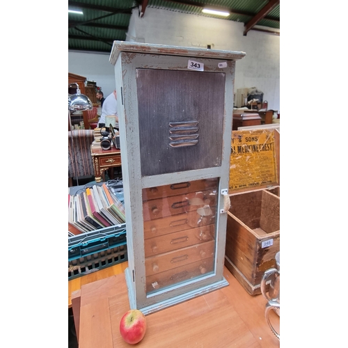 343 - A neat sized wooden chest of 6 drawers. With large shelf and glass door. Reminiscent of apothecary d... 