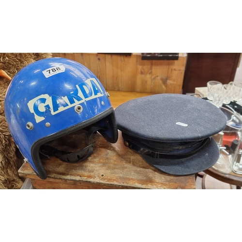 An authentic 1980s Garda Siochana riot helmet, size 7 1/2 along with a  peaked uniform cap.