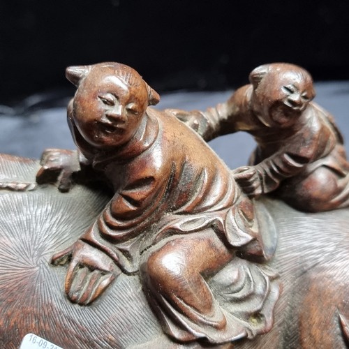 144 - An Antique Japanese intricately carved Asian wooden statue on a carved wooden base, showing two men ... 