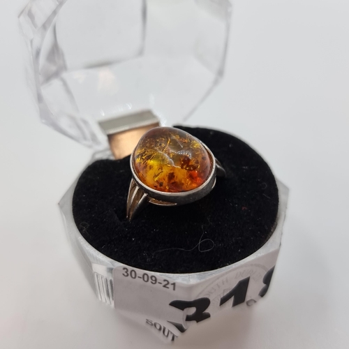 318 - A sterling silver stamped 925 Larger  amber cabachon ring. Size O, weight 2.35g.